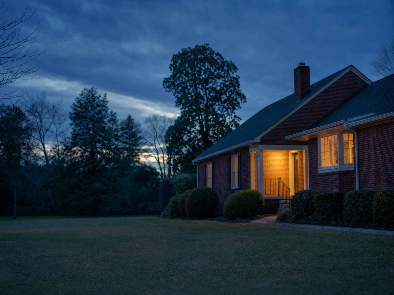 A calm house at dusk with one porch light on, a family matter resolving with dignity.